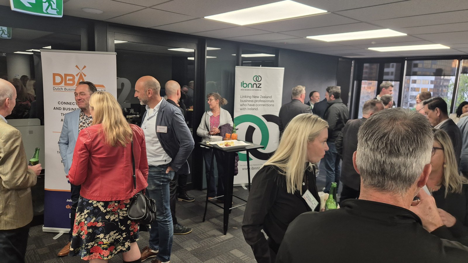 Attendees networking in front of the DBA and IBNNZ banners