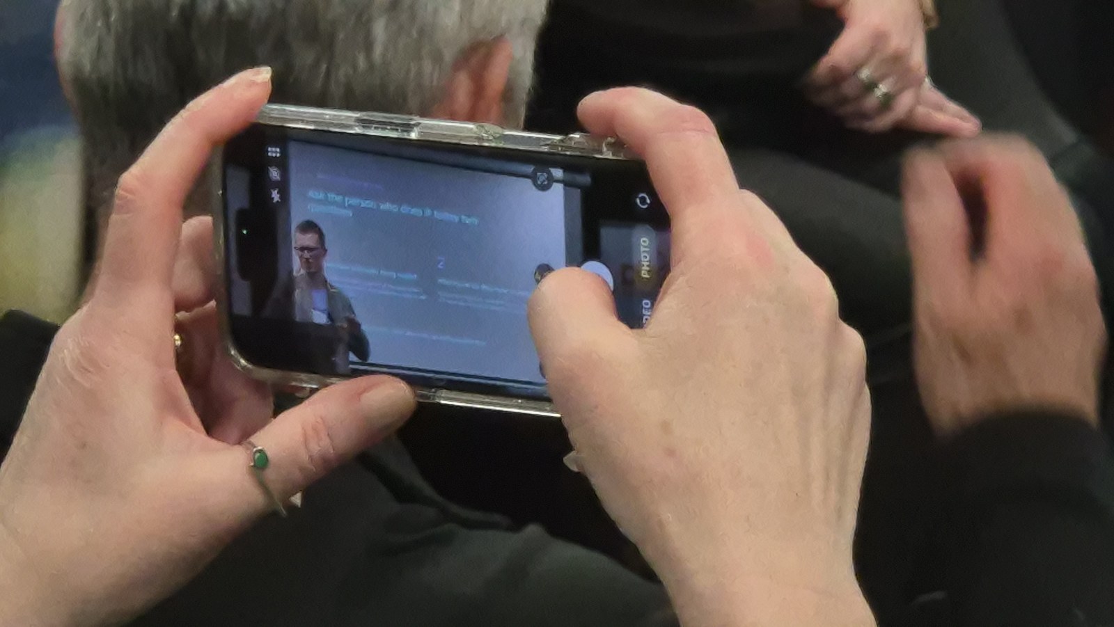 An attendee photographing Matt Reid's slide on their phone