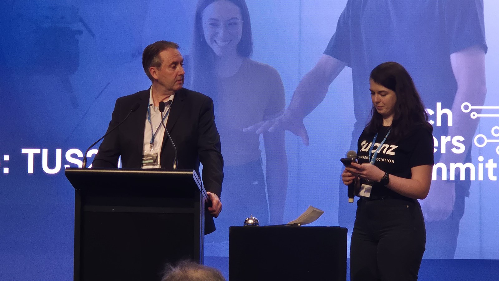 Mark Darrow at the lectern during the question and answer session, with the summit MC beside him reading questions from a phone